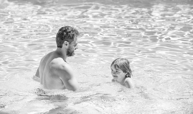 Gelukkige familie van vader en zoon die plezier hebben in de familie van het zomerzwembad