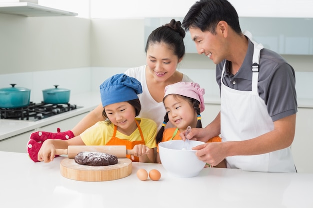 Gelukkige familie van vier die koekjes in keuken voorbereiden