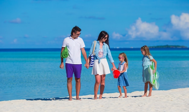 Gelukkige familie van vier op wit strand