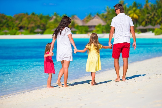 Gelukkige familie van vier op wit strand