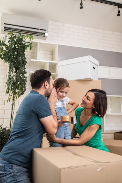 Gelukkige familie verhuizen naar hun nieuwe huis en kartonnen dozen uitpakken.