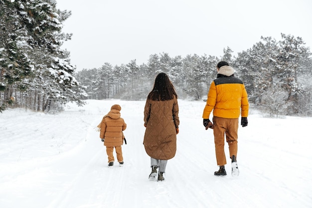 Gelukkige familie wandelen in de winter buiten in de sneeuw