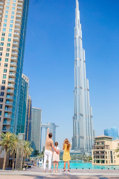 Gelukkige familie wandelen in dubai met burj khalifa wolkenkrabber