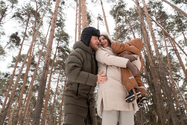 Gelukkige familie wandelen in het bos in de winter