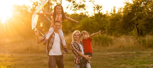 Gelukkige familie wandelen in het veld en kijken naar zonsondergang