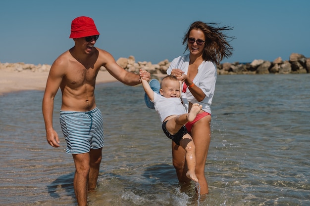 Gelukkige familie wandelen op een strand hand in hand