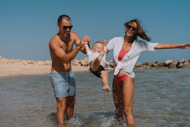 Gelukkige familie wandelen op een strand hand in hand