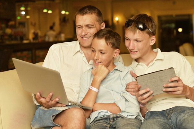 Gelukkige familie zitten met laptop op tafel