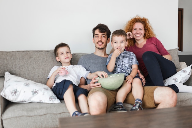 Gelukkige familie zittend op de bank televisie kijken