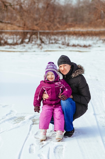 Gelukkige familiemoeder en de dochter van het babymeisje spelen die in de winter in openlucht lachen