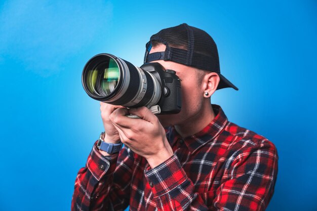 Foto gelukkige fotograaf die foto's maakt en zijn camera controleert in een studio die schiet als content creator