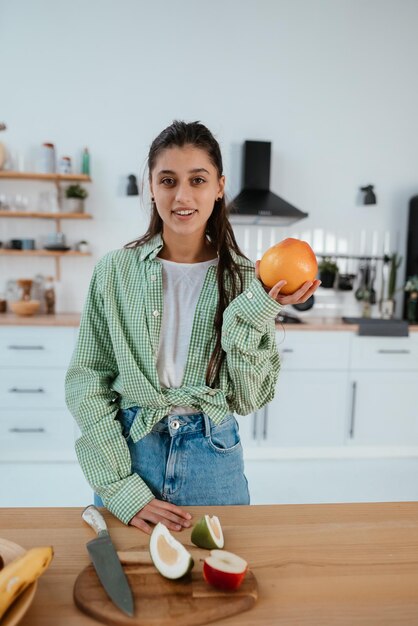 Gelukkige gezonde vrouw die ontbijt in een keuken maakt