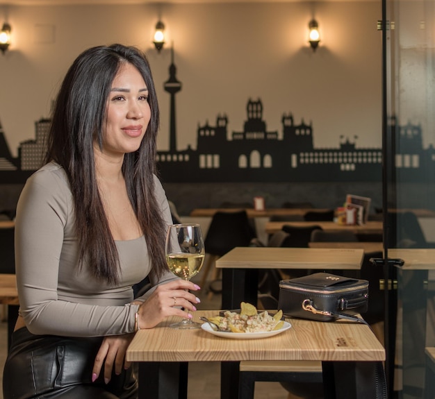 Gelukkige glimlach en koffie winkel jonge vrouw geniet van een glas wijn in een restaurant