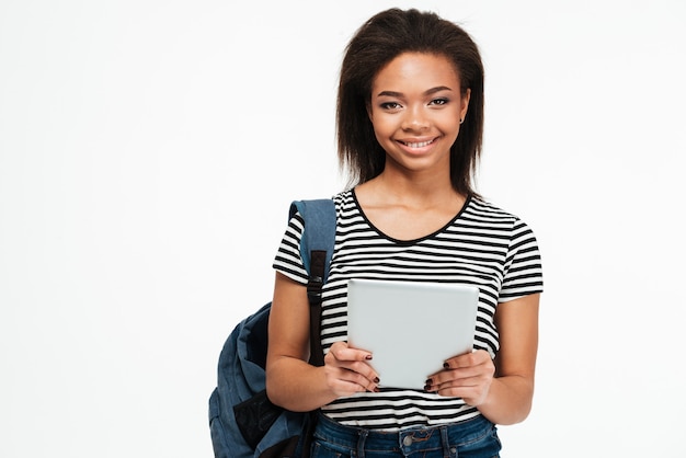 Foto gelukkige glimlachende afrikaanse tienervrouw met rugzak die pc-tablet gebruiken