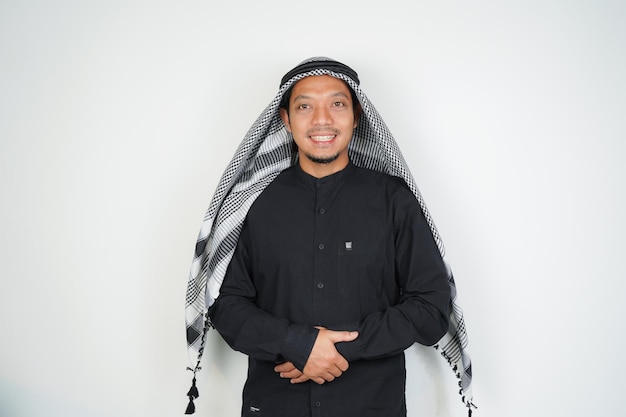 Gelukkige glimlachende Aziatische moslimman in een Arabische turban sorban staande met Eid groet gebaar Ramadan