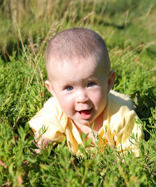 Gelukkige glimlachende baby in gras