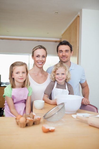 Gelukkige glimlachende familie die koekjes voorbereidt