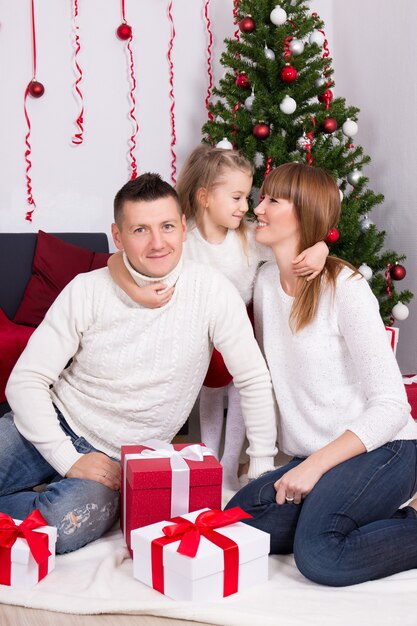 Gelukkige glimlachende familie die thuis Kerstmis of Nieuwjaar viert