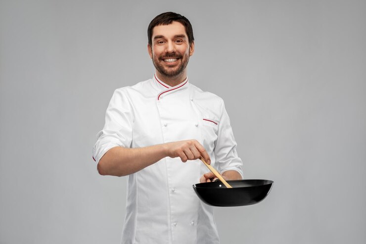 Foto gelukkige glimlachende mannelijke chef koken eten op een pan