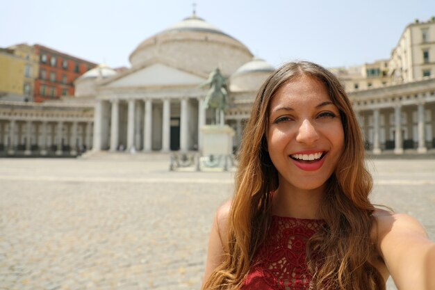 Gelukkige glimlachende vrouw in napels met piazza del plebiscito-vierkant, napels in italië