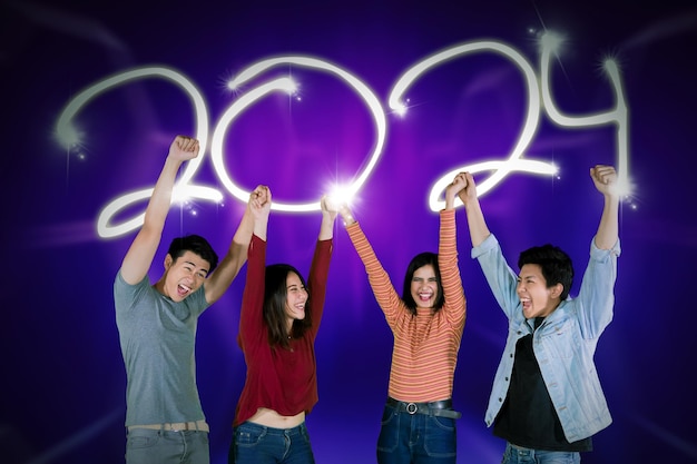 Gelukkige groep jonge aziaten die dansen om het nieuwe jaar 2024 te vieren