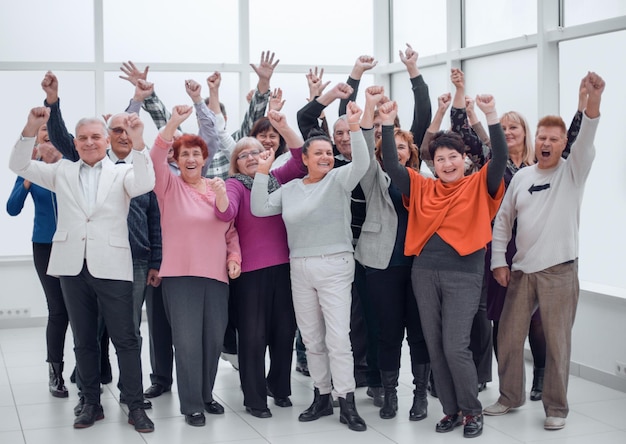 Gelukkige groep mensen die hun hand opsteken om zich te verheugen over de overwinning