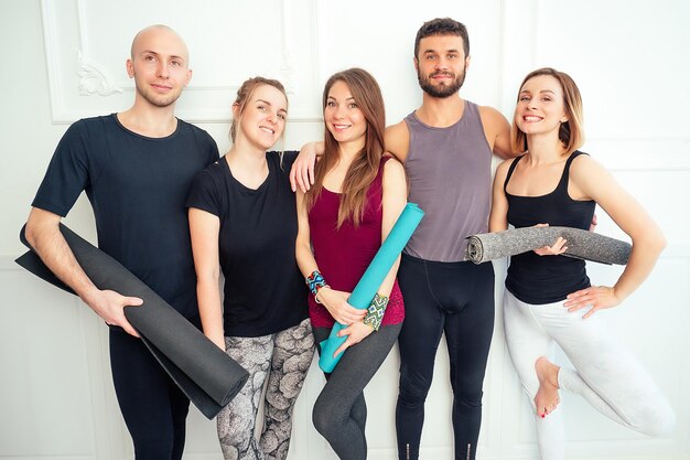 Gelukkige groep mensen van mannen en vrouwen die yoga beoefenen in plezier in de studio. meditatiegroepen en ondersteuning in de yogales. yoga, maat, man, vrouw, veel mensen