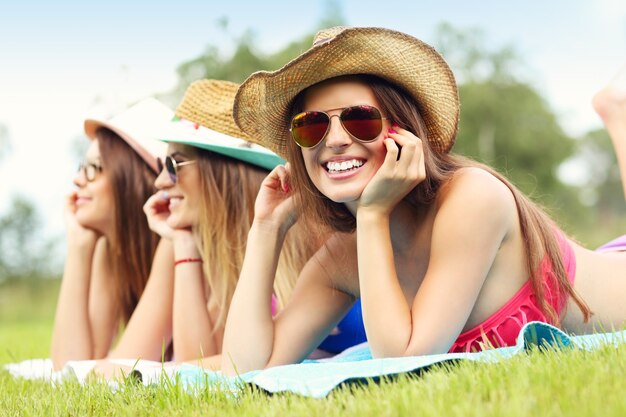 Foto gelukkige groep vrienden die op het gras liggen en zonnebaden