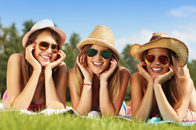 Foto gelukkige groep vrienden die op het gras liggen en zonnebaden