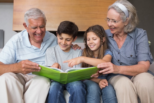 Gelukkige grootouders en grandkids die albumfoto bekijken