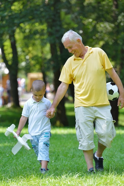 gelukkige grootvader en kind hebben plezier en spelen in het park
