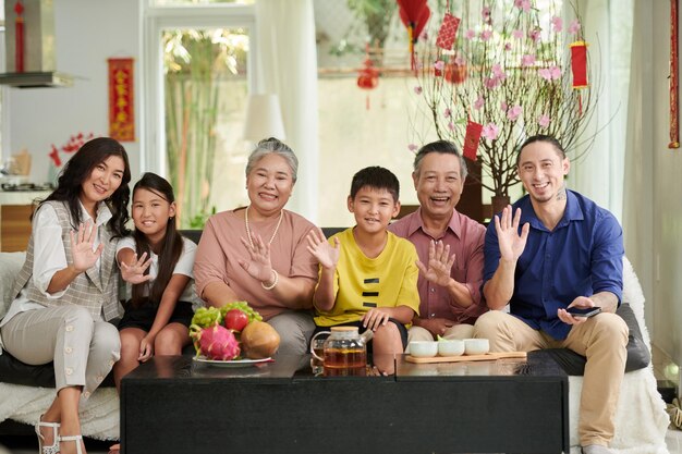 Gelukkige grote familie met thee en vers fruit thuis bij het vieren van tet