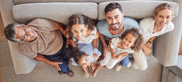 Gelukkige grote familieglimlach op de bank en bovenaanzicht van generaties grootouders en ouders brengen samen tijd door in de woonkamer Hou van diversiteit en koppel met meisjeskinderen oma en opa ontspannen thuis