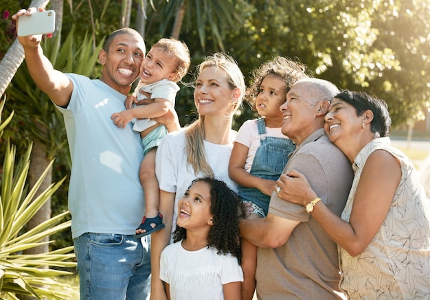 Gelukkige grote familieknuffel en selfie in fotografie-binding of vakantie in de buitenlucht samen Ouders, grootouders en kinderen glimlachen voor fotogeheugen of sociale media tijdens een weekendje weg of pauze