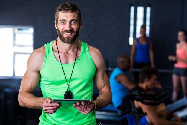 gelukkige hipster met tablet in de sportschool