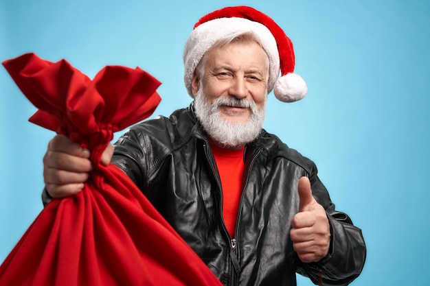 Gelukkige hogere mens die Kerstmishoed en zwart jasje draagt