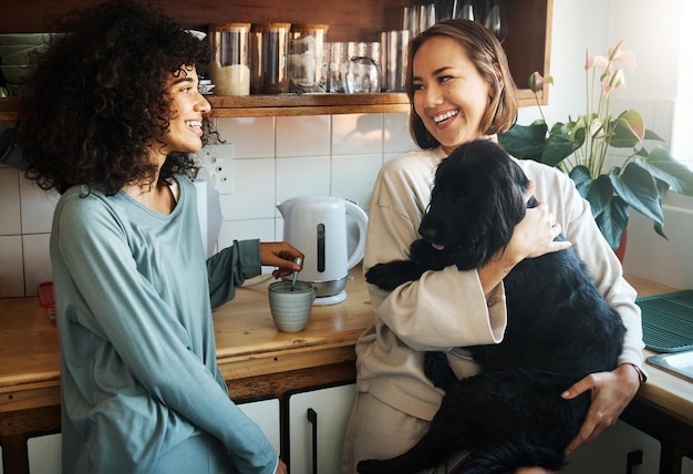 Gelukkige hond en ochtend met lesbisch koppel in de keuken voor ontspannende ondersteuning en verzorging Hondendierenliefde en glimlach met homoseksuele vrouwen en huisdierpup thuis voor het samenbrengen van speels en geluk