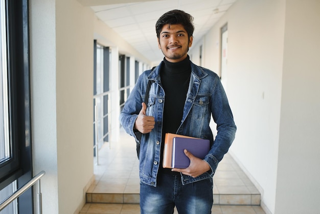 Gelukkige Indiase mannelijke student aan de universiteit