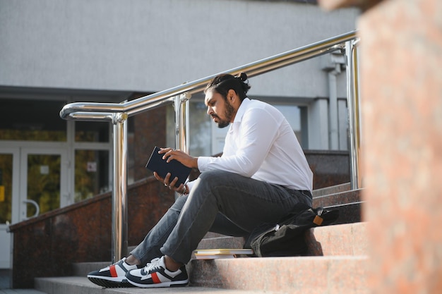 Gelukkige Indiase mannelijke student aan de universiteit