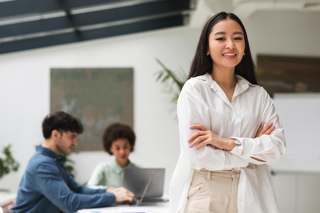 Gelukkige japanse zakenvrouw die vertrouwen uitdrukt in een coworking-kantoor