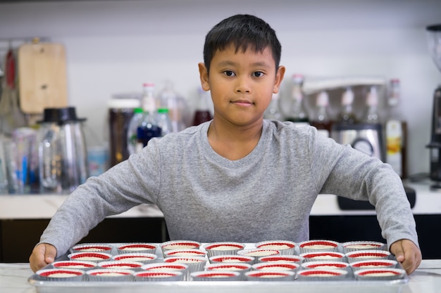 Gelukkige jong geitjejongen die een cake maakt