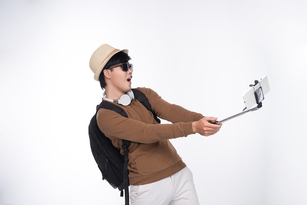 Gelukkige jonge Aziatische man die zelfportretfotografie maakt via slimme telefoon