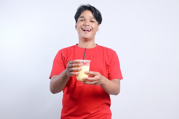 Gelukkige jonge Aziatische man met appelsap in een plastic beker op een witte achtergrond