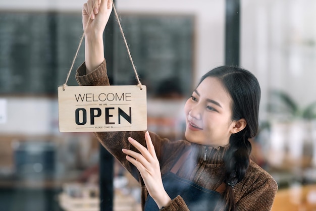 Gelukkige jonge bedrijfseigenaar die zich met open tekenraad bevindt.