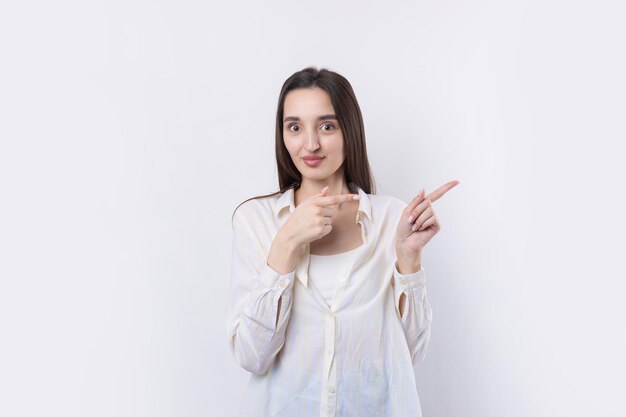 Gelukkige jonge blanke vrouw in een shirt wijzende vingers weg