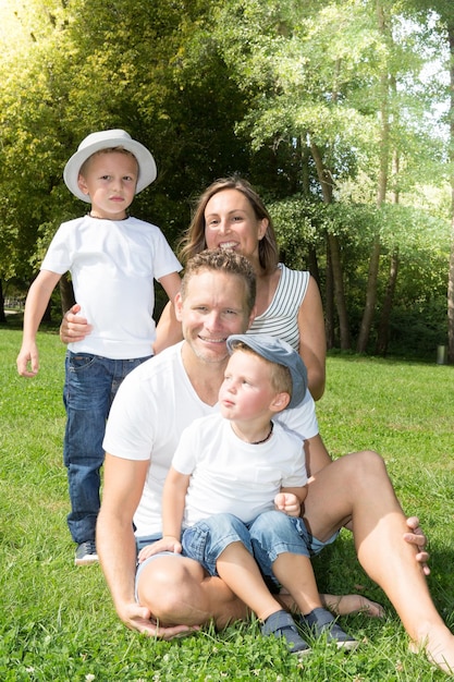 Gelukkige jonge blonde familie zittend op gras