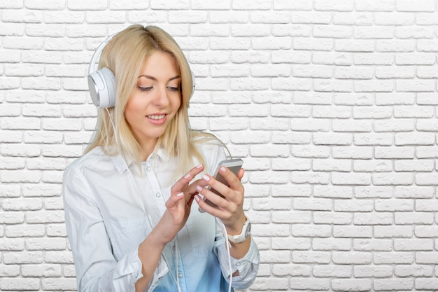 Gelukkige jonge blondevrouw die aan muziek luisteren