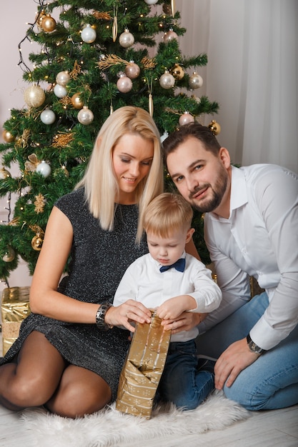 Gelukkige jonge familie die Kerstmis thuis viert.