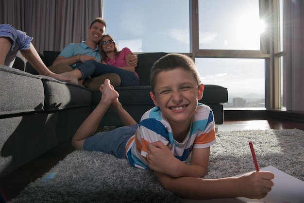 Gelukkige jonge familie die thuis samen op de vloer speelt met een tablet en een tekenset voor kinderen