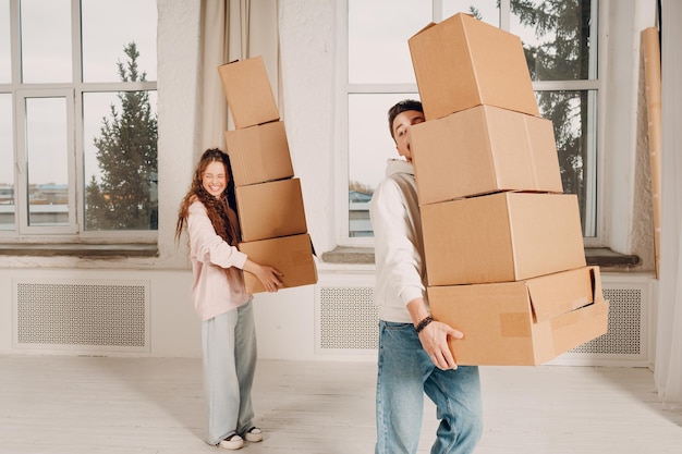 Foto gelukkige jonge familie echtpaar man en vrouw verhuizen met kartonnen dozen naar nieuw landgoed huis appartement